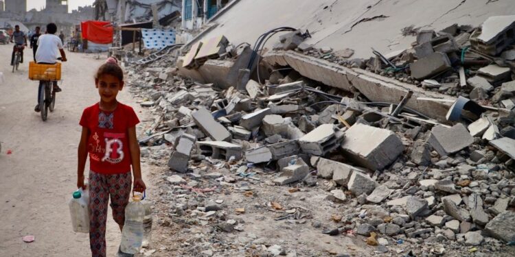 A child walks past ruined buildings in Gaza. Photo: