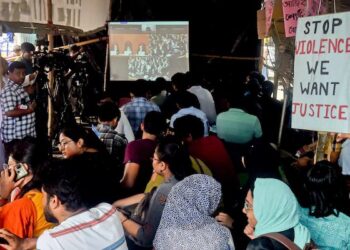 Students of RG Kar Medical College watch Supreme Court hearing on their protest site. PTI