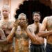 Men pray after applying cow dung on their bodies in the belief that it will boost their immunity against Covid-19 at the Shree Swaminarayan Gurukul Vishwavidya Pratishthanam Gaushala on the outskirts of Ahmedabad in May 2021. | Reuters