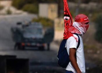 A Palestinian youth carries a flag of the Popular Front for the Liberation of Palestine (PLFP) in Ramallah, in the occupied West Bank. AFP