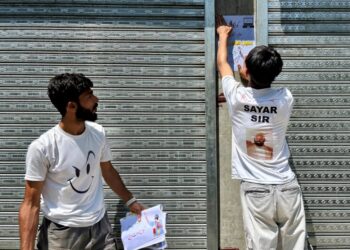 Reshi's supporters paste posters on the walls of a shopping complex in Kulgam district, once a hotbed of militancy.