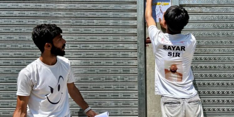 Reshi's supporters paste posters on the walls of a shopping complex in Kulgam district, once a hotbed of militancy.