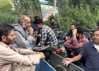 Kashmiri migrants without work idle at the Solan bus stand