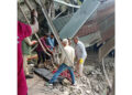 Body of female pilgrim being retrieved from damaged iron structure following landslide.