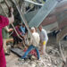 Body of female pilgrim being retrieved from damaged iron structure following landslide.