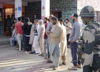 People wait in a queue to cast their votes during the third and final phase of Jammu and Kashmir Assembly elections, at Handwara in Kupwara district