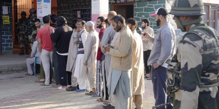 People wait in a queue to cast their votes during the third and final phase of Jammu and Kashmir Assembly elections, at Handwara in Kupwara district