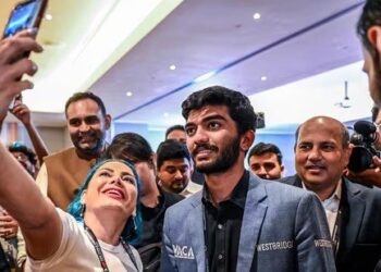 A fan takes a selfie with India's grandmaster Gukesh Dommaraju (C) after his win against China's chess grandmaster Ding Liren