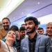 A fan takes a selfie with India's grandmaster Gukesh Dommaraju (C) after his win against China's chess grandmaster Ding Liren