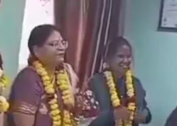 Both the husband and wife (second and second L) were seen wearing garlands and smiling during his farewell at office.