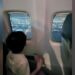 Photo posted by Kang Ko shows his three-year-old son peering out of a plane window on their flight to Bangkok.